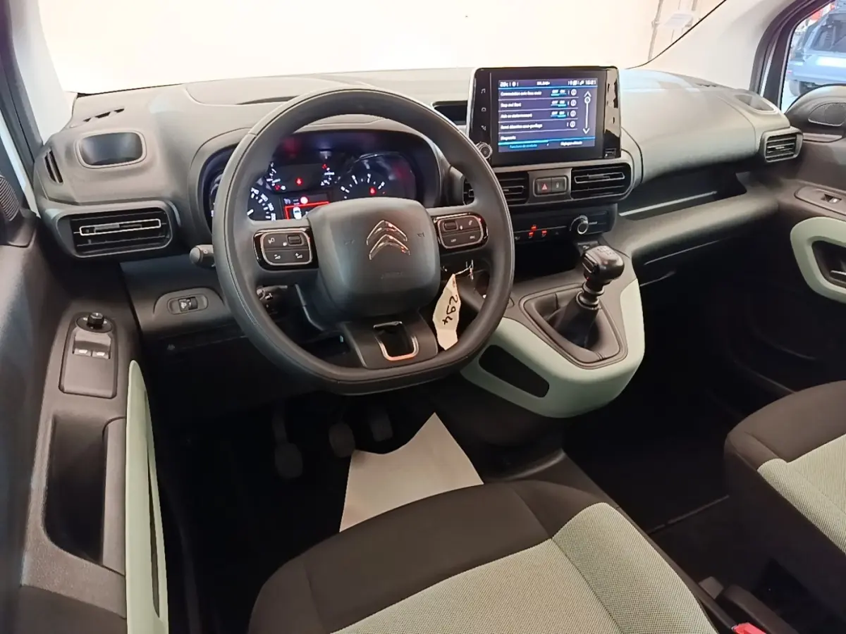 Intérieur du Citroën Berlingo 2022 vue du poste de conduite, volant multifonctions et écran tactile central visibles.