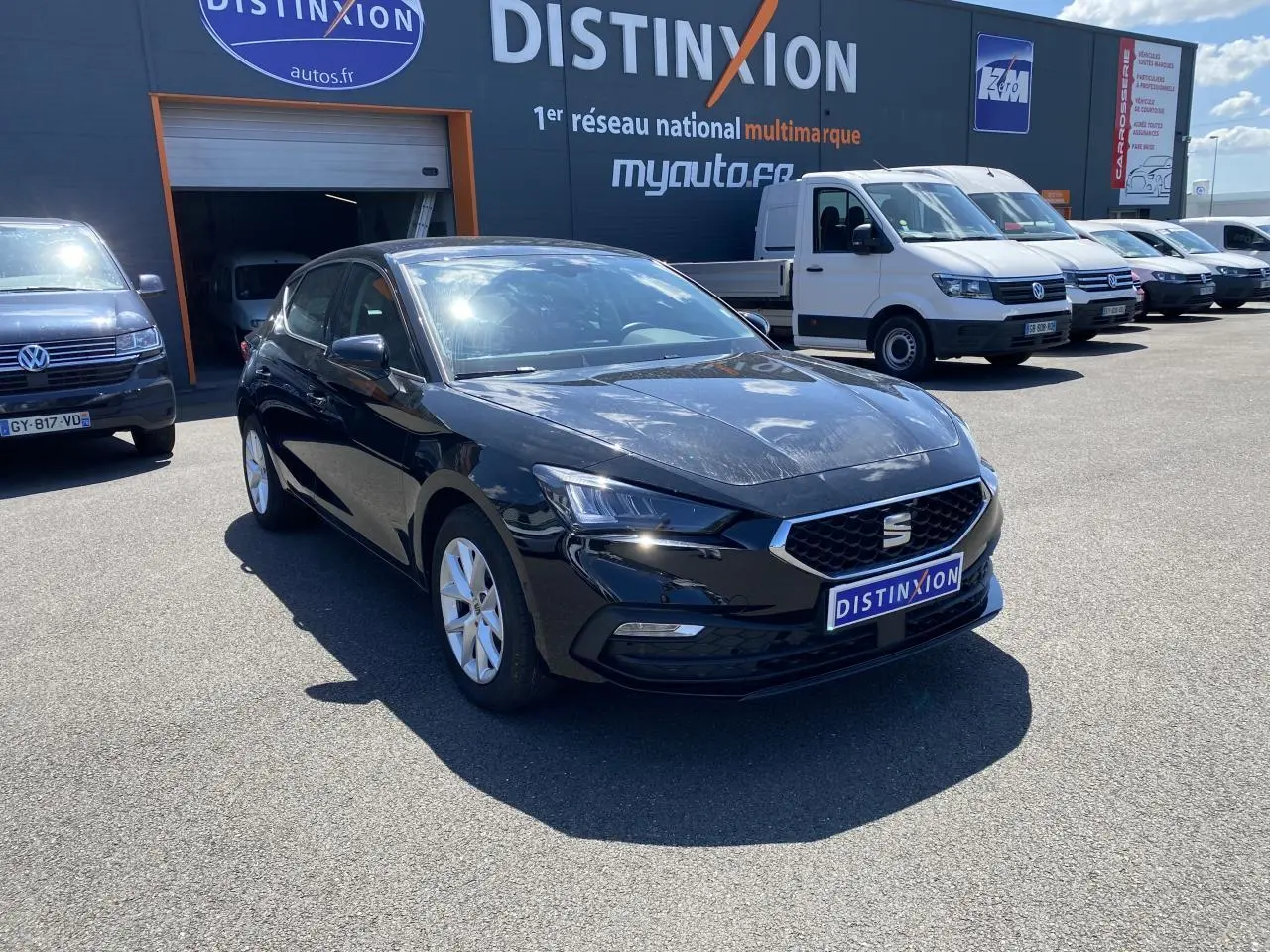 SEAT Leon 2024 noir Midnight vue 3/4 avant droit, avec calandre hexagonale et jantes argentées visibles.