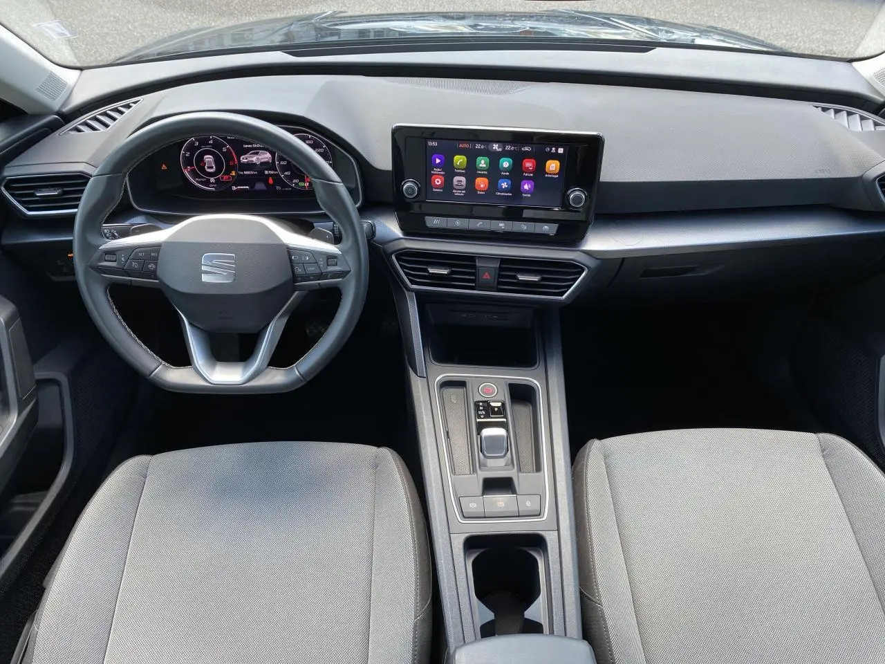 Vue intérieure frontale du poste de conduite du SEAT LEON 2024 avec tableau de bord numérique et écran tactile central.