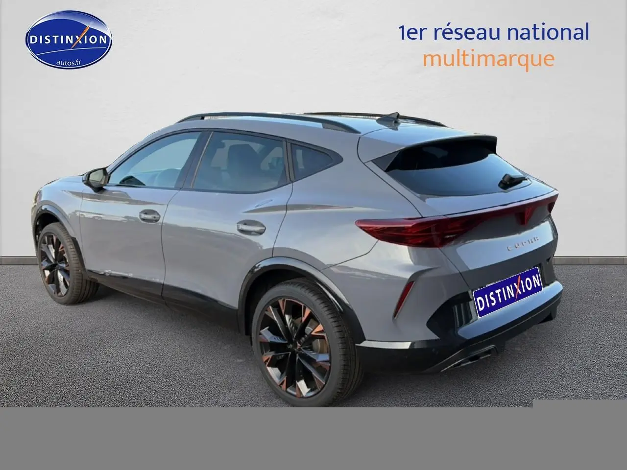 Vue 3/4 arrière droite d’un CUPRA Formentor gris graphene avec jantes noires et détails cuivrés, vitres arrière surteintées.