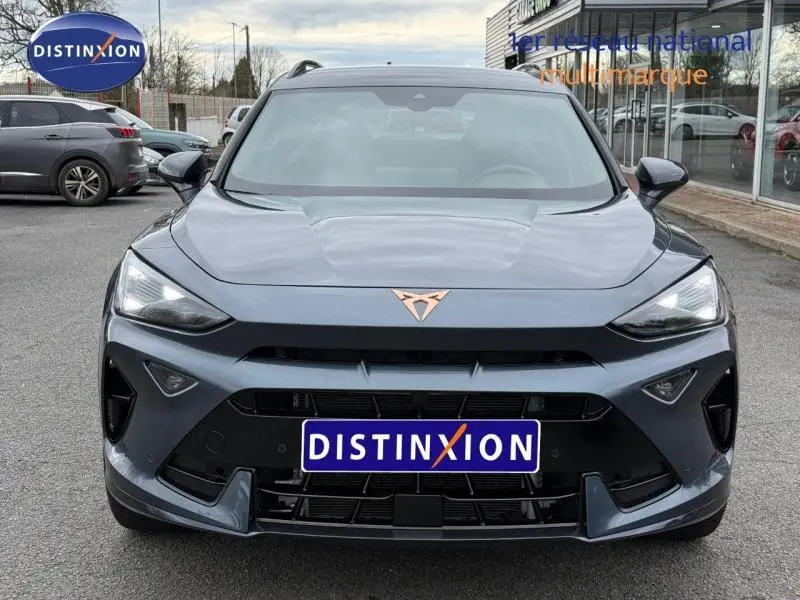 Vue frontale d'une CUPRA Formentor 1.5 eTSI Hybrid 150ch V DSG7 en gris magnétique mat avec logo cuivré distinctif.