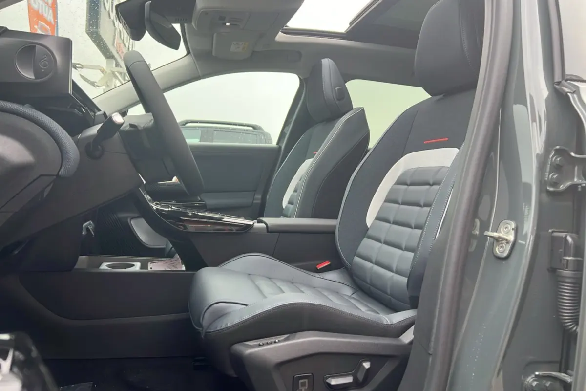 Vue intérieure côté conducteur du Citroën C5 Aircross vert astoria, sièges avant cuir et tissu gris avec accoudoir central.