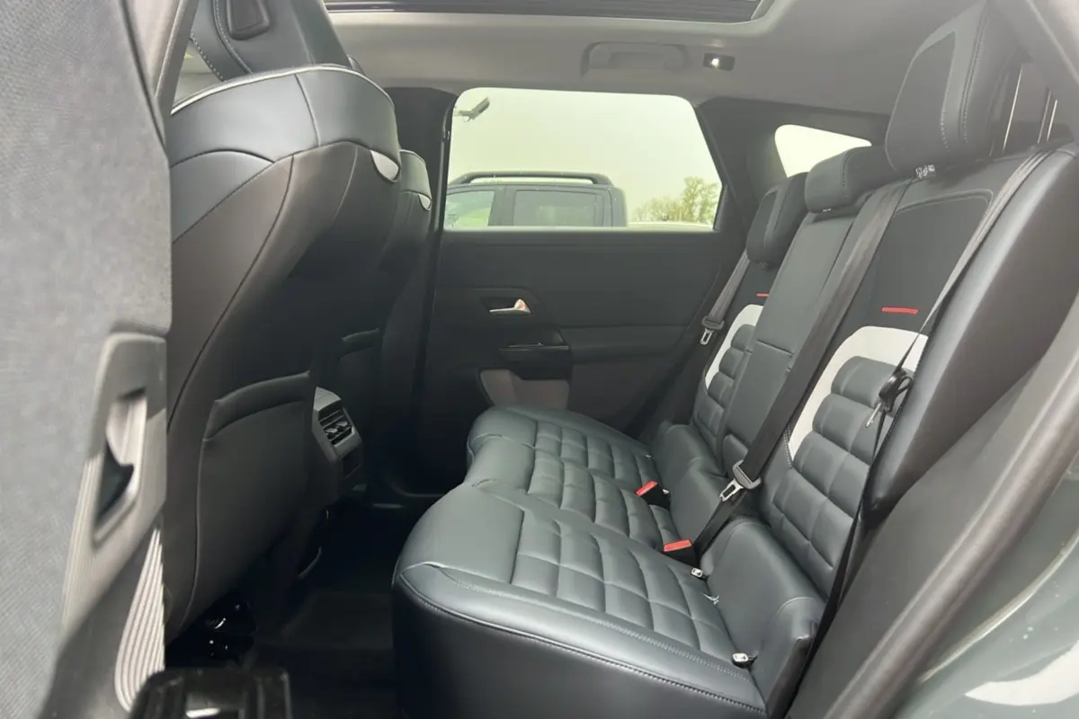 Vue intérieure arrière côté droit du Citroën C5 Aircross 2026, sièges cuir noirs avec surpiqûres et toit ouvrant panoramique.