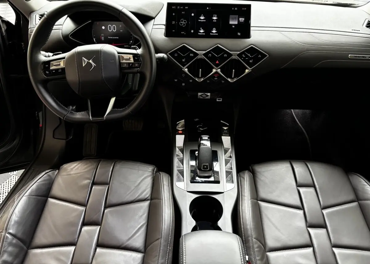 Vue intérieure avant du DS3 2024, tableau de bord et console centrale avec écran tactile 10,3 pouces et sièges cuir gris foncé.