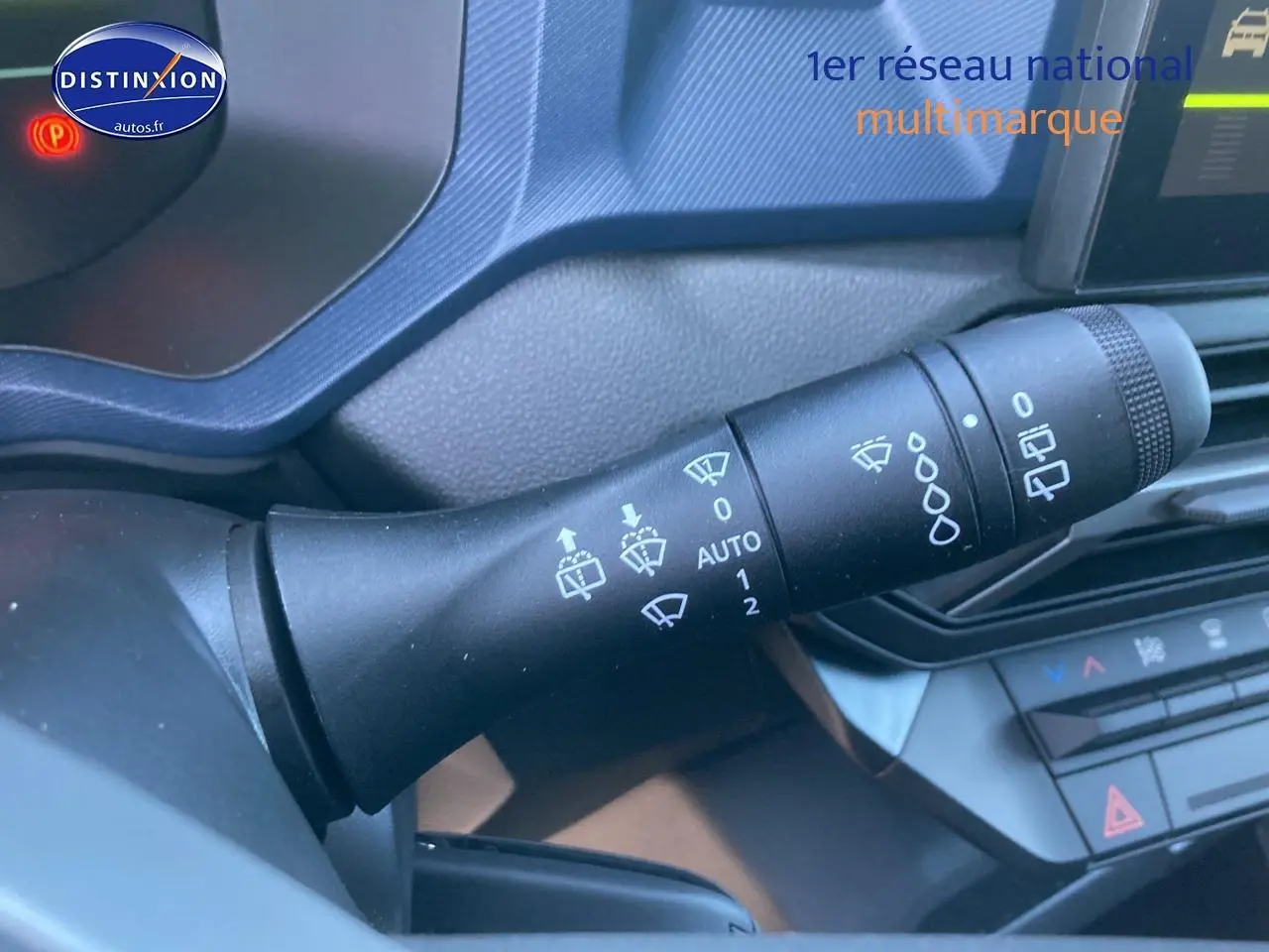 Gros plan sur la commande des essuie-glaces du tableau de bord du Dacia Duster 2025, intérieur noir.