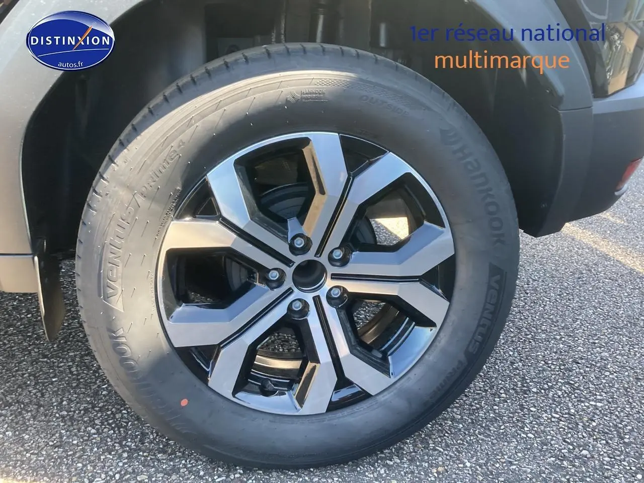 Gros plan sur la jante alu noire et argentée du côté arrière droit d’un Dacia Duster noir 2025.