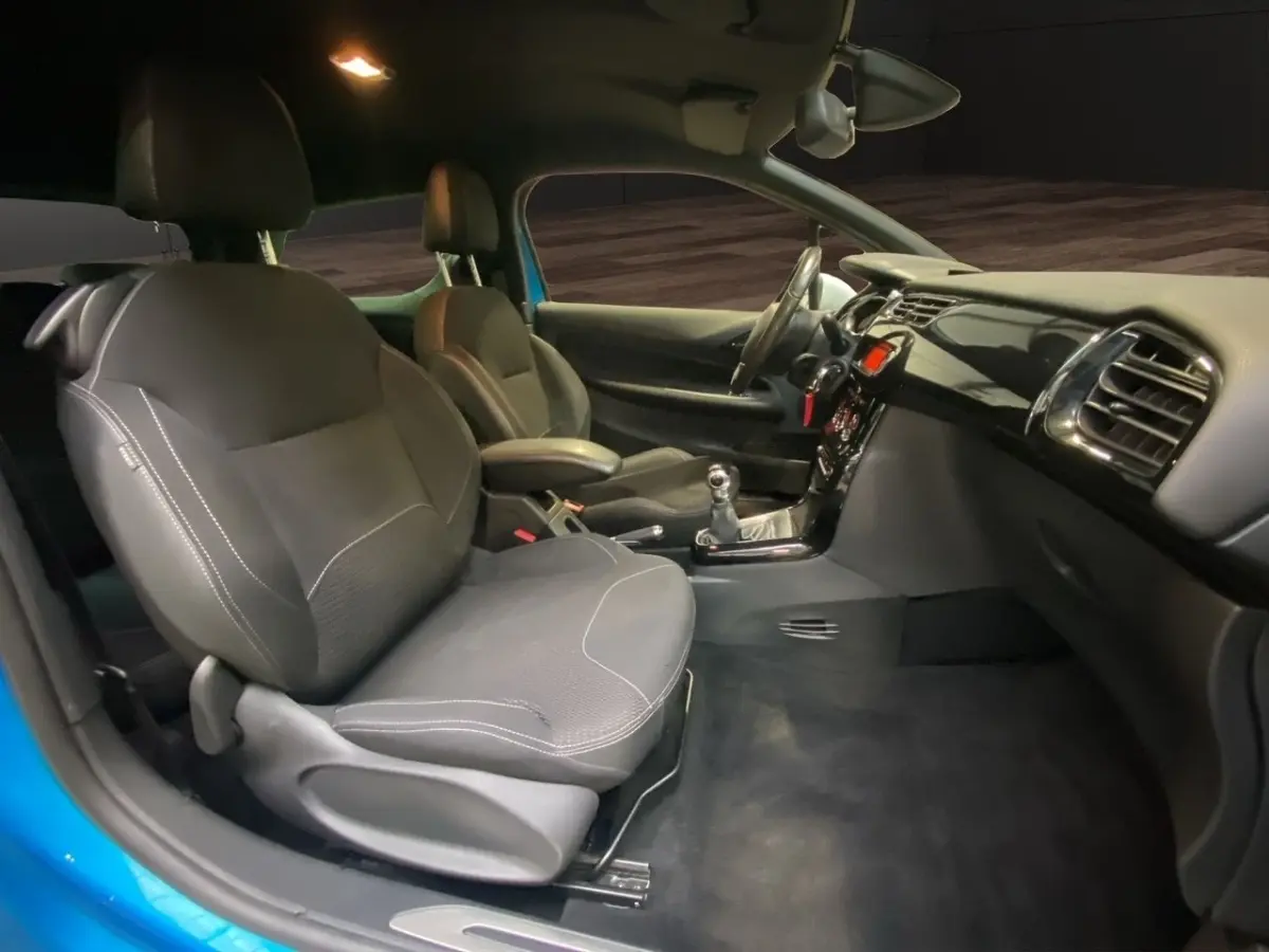 Vue intérieure côté droit de la Citroën DS3 e-HDi 90 Airdream So Chic bleu, avec sièges tissu gris et volant cuir alu.