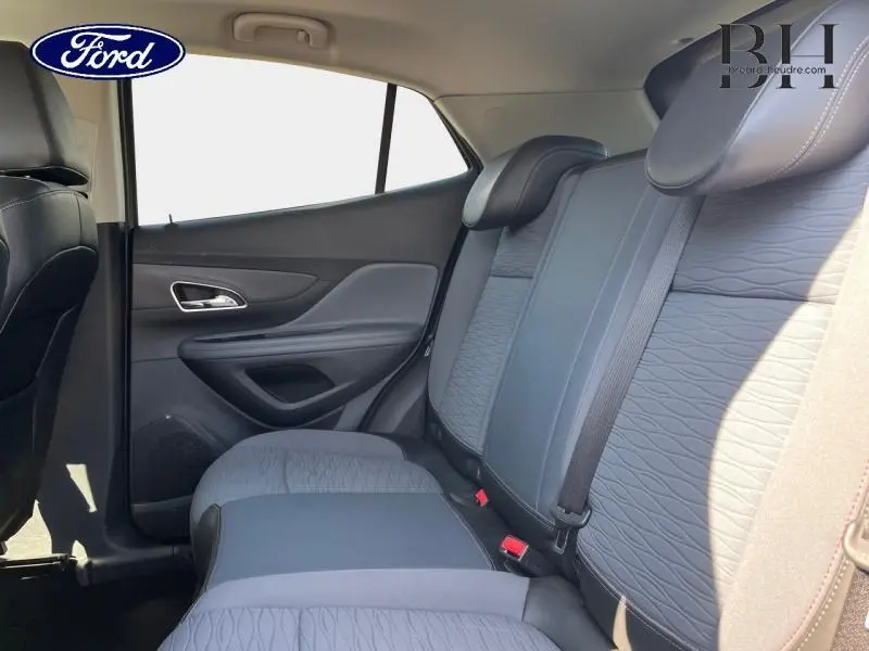 Vue intérieure côté droit des sièges arrière en tissu gris d’un Opel Mokka 2016 avec ceinture de sécurité visible.