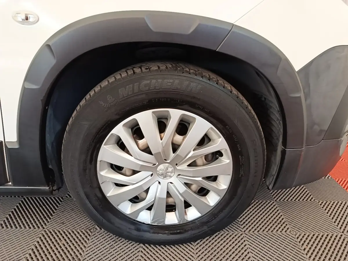 Gros plan sur la roue avant droite blanche du Peugeot Rifter 2020 avec jante argentée et pneu Michelin.