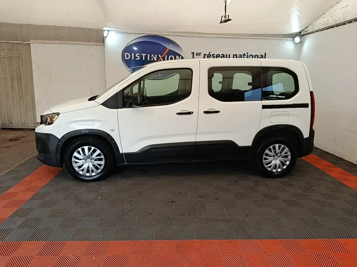 Peugeot Rifter blanc vue de profil côté gauche, avec protections noires sur les bas de caisse et jantes argentées.