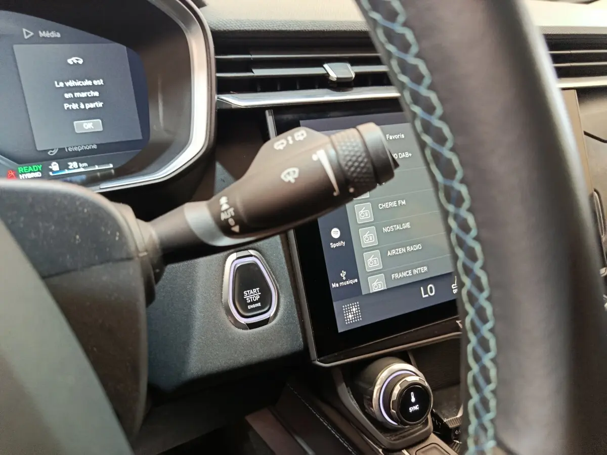 Vue intérieure côté conducteur du tableau de bord bleu avec bouton start/stop et écran tactile multimédia du Link & Co 01 hybride rechargeable.