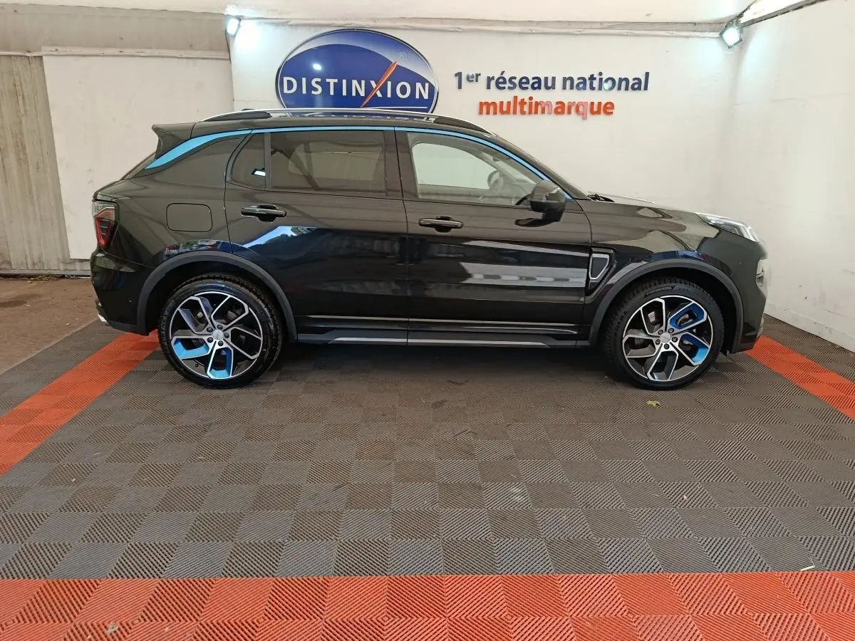 Vue latérale droite d'un SUV Link & Co 01 hybride rechargeable bleu foncé avec jantes bicolores et toit noir.