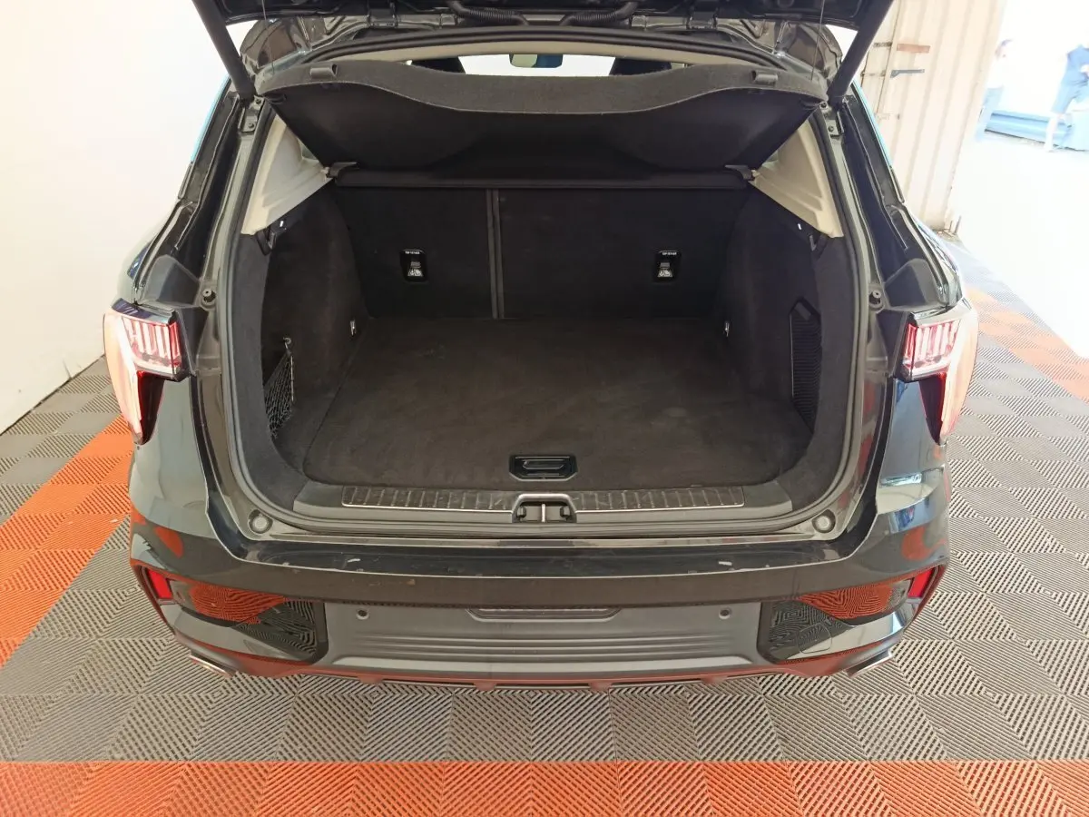 Coffre ouvert vu de l'arrière d'un SUV Link & Co 01 noir, montrant un espace de chargement vide et propre.