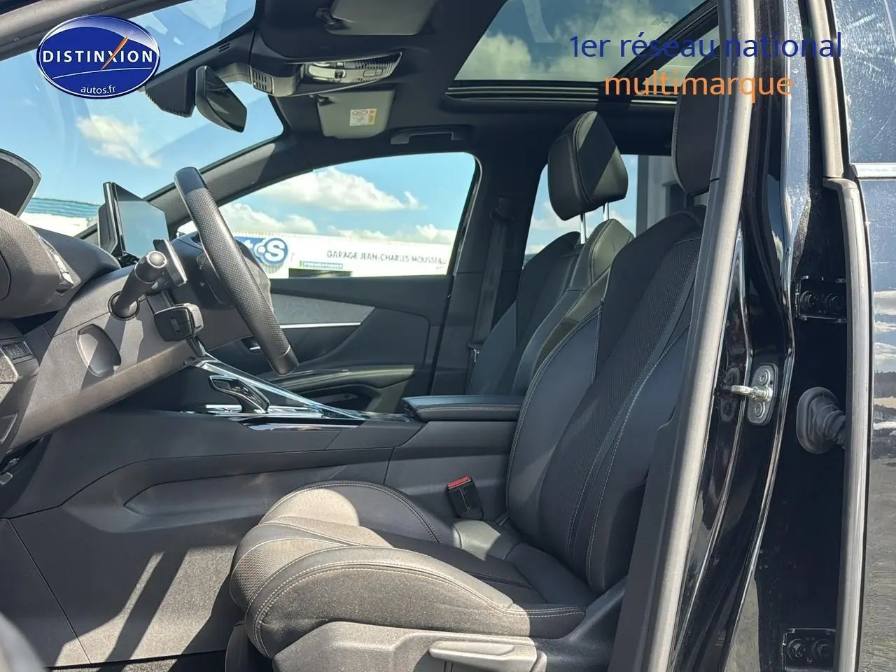 Intérieur noir du Peugeot 5008 2022, vue côté conducteur avec sièges cuir et toit ouvrant panoramique visible.