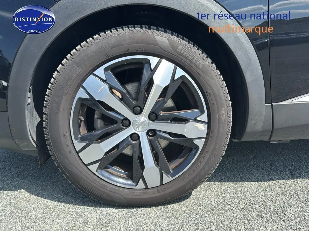 Gros plan sur la jante alu noire et argentée du côté avant droit d'un Peugeot 5008 noir métal 2022.