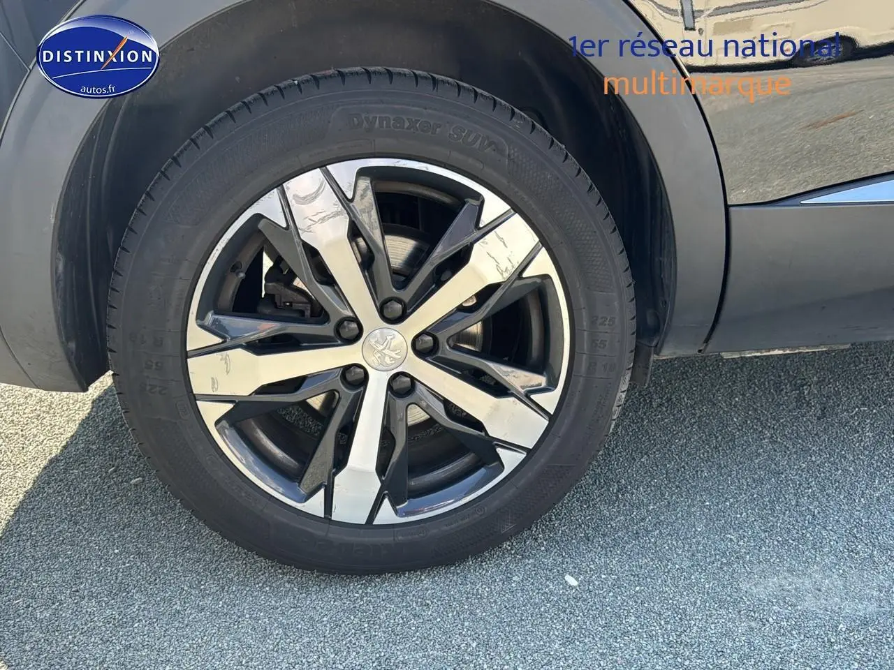 Gros plan sur la jante alu bicolore du côté gauche d'un Peugeot 5008 noir métal 2022.