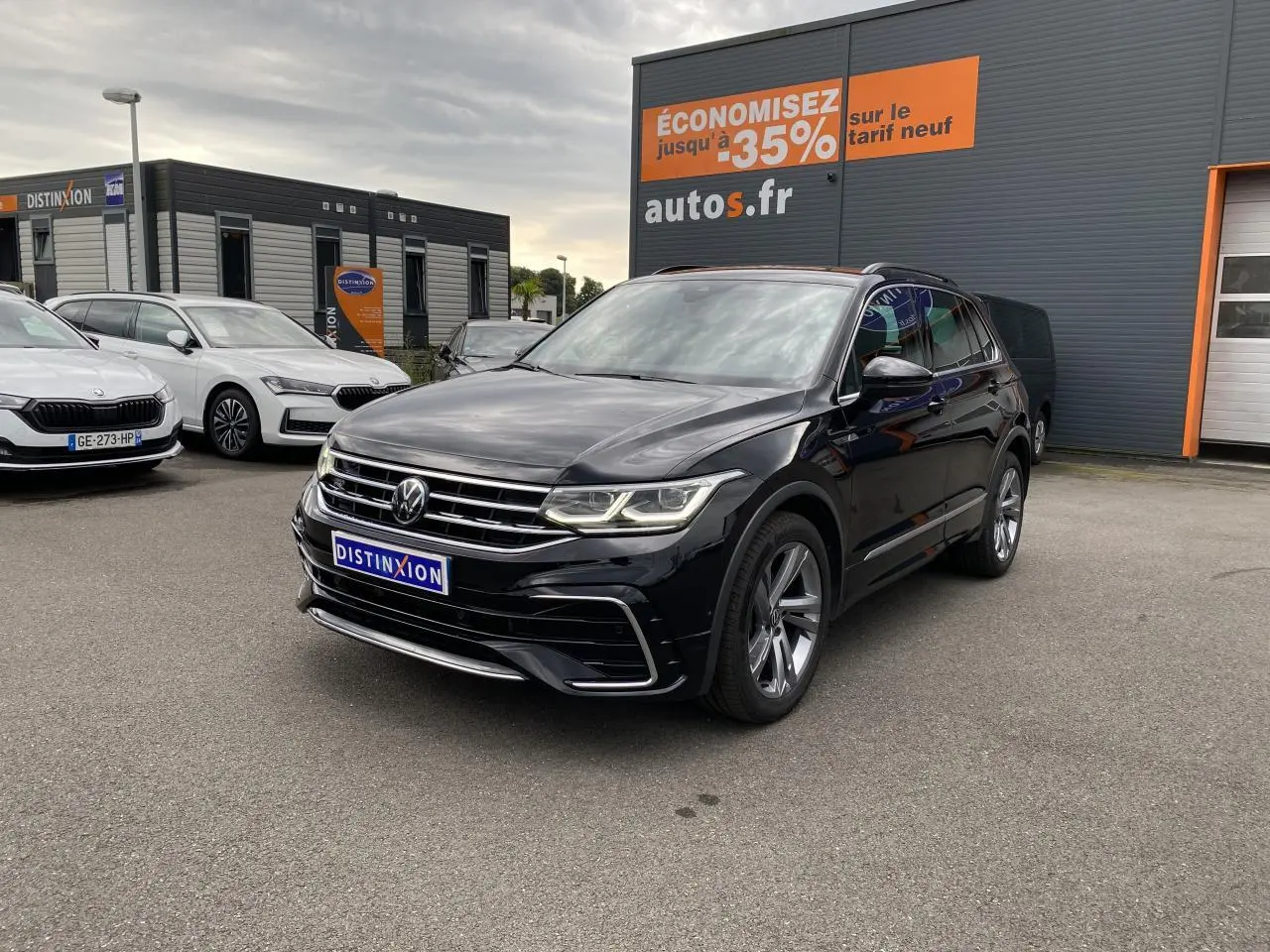 Volkswagen Tiguan noir intense métallisé en 3/4 avant droit avec jantes alliage et projecteurs Matrix LED allumés.