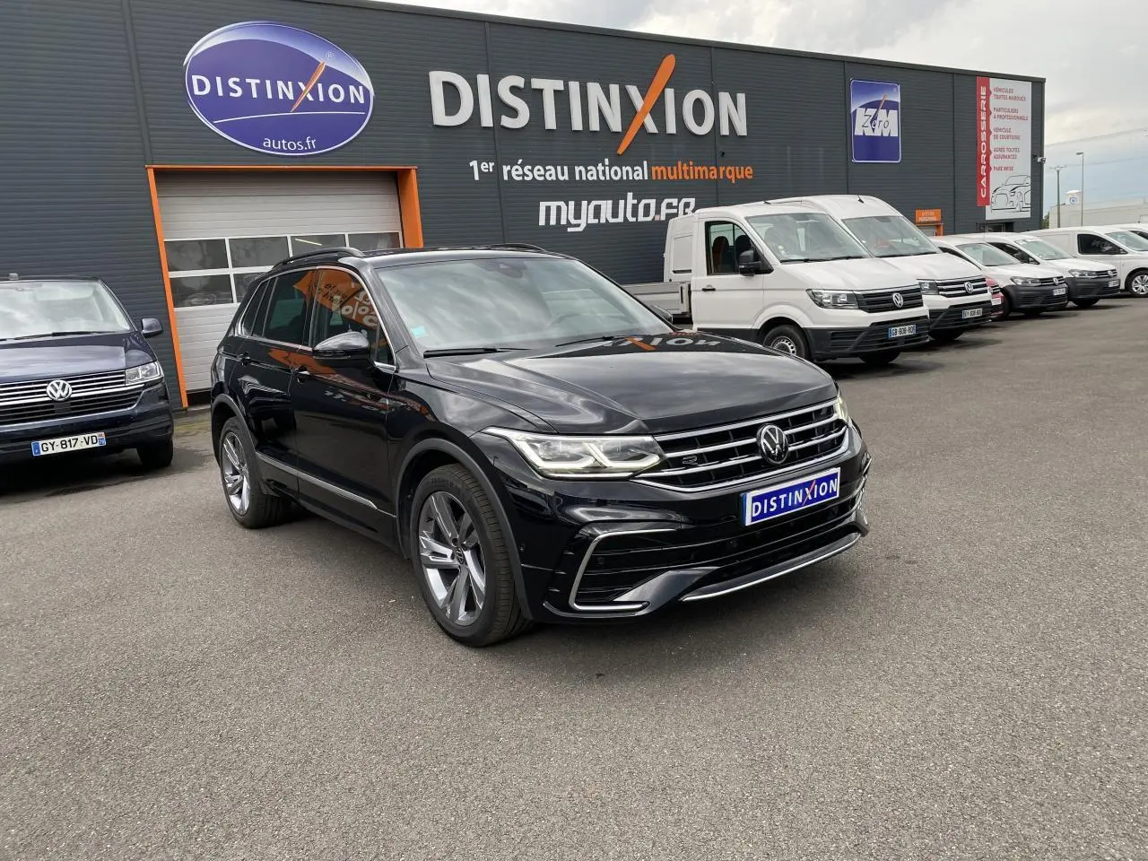 Volkswagen Tiguan noir intense métallisé en 3/4 avant avec jantes alliage et projecteurs LED Matrix allumés.