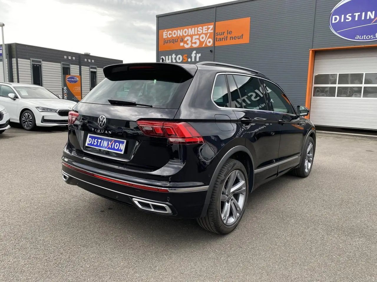Vue 3/4 arrière droite d'un Volkswagen Tiguan noir intense métallisé avec finition R-Line et jantes alliage 19 pouces.