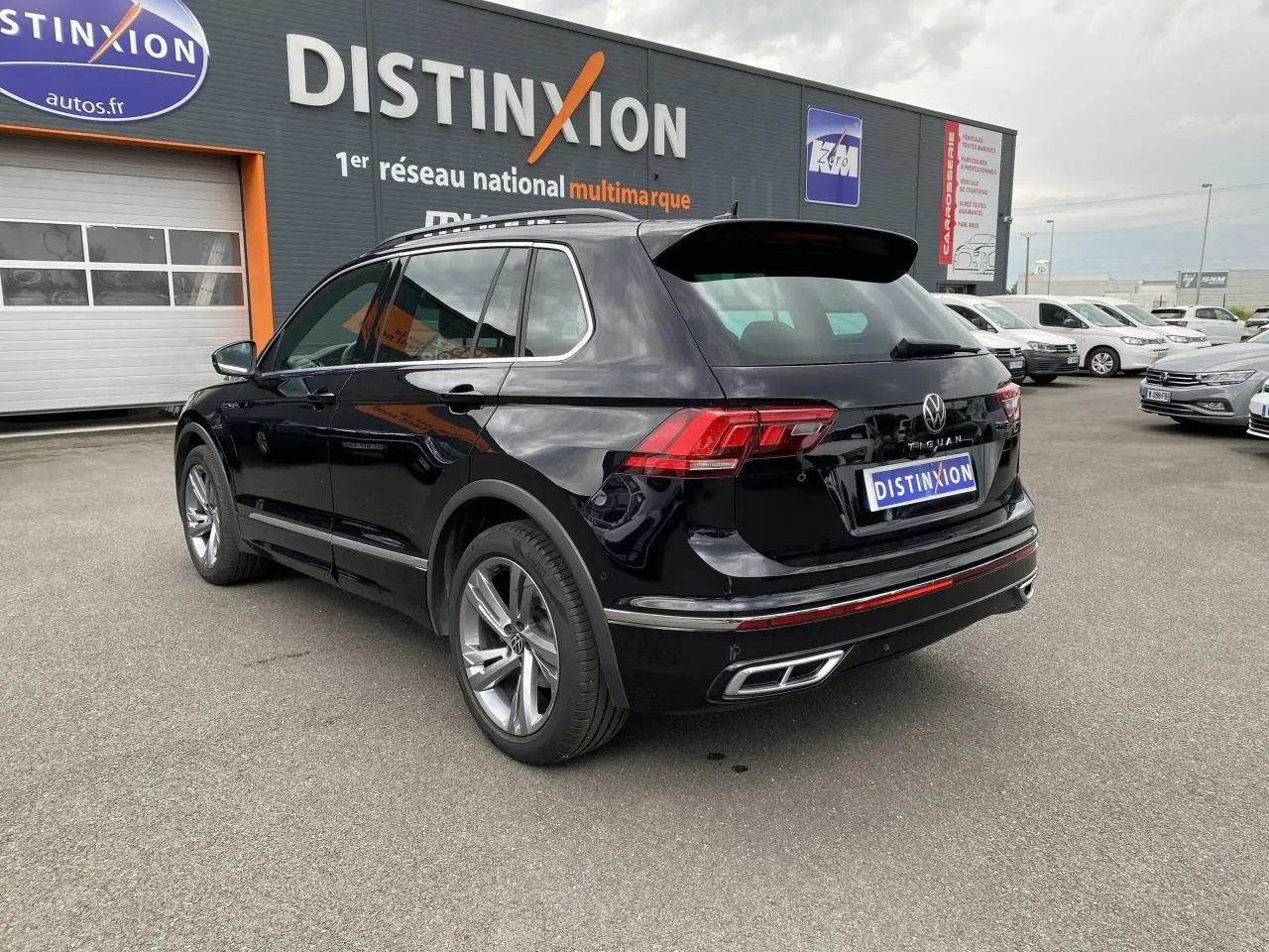 Volkswagen Tiguan noir intense métallisé vu en 3/4 arrière droit, avec jantes alliage et feux LED distinctifs.