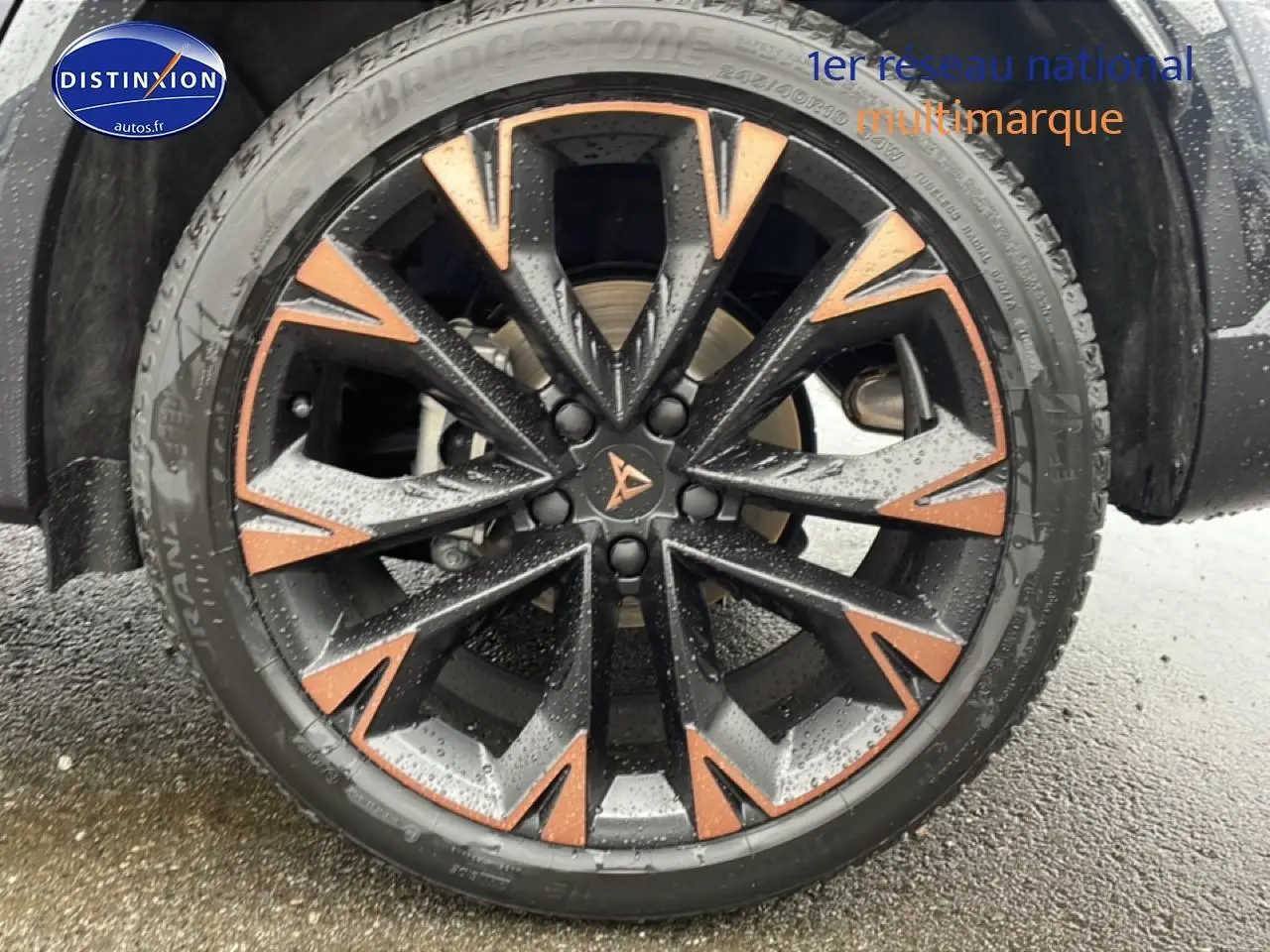 Gros plan sur une jante 19 pouces bicolore noir et cuivre du CUPRA Formentor gris graphene, avec logo central visible.