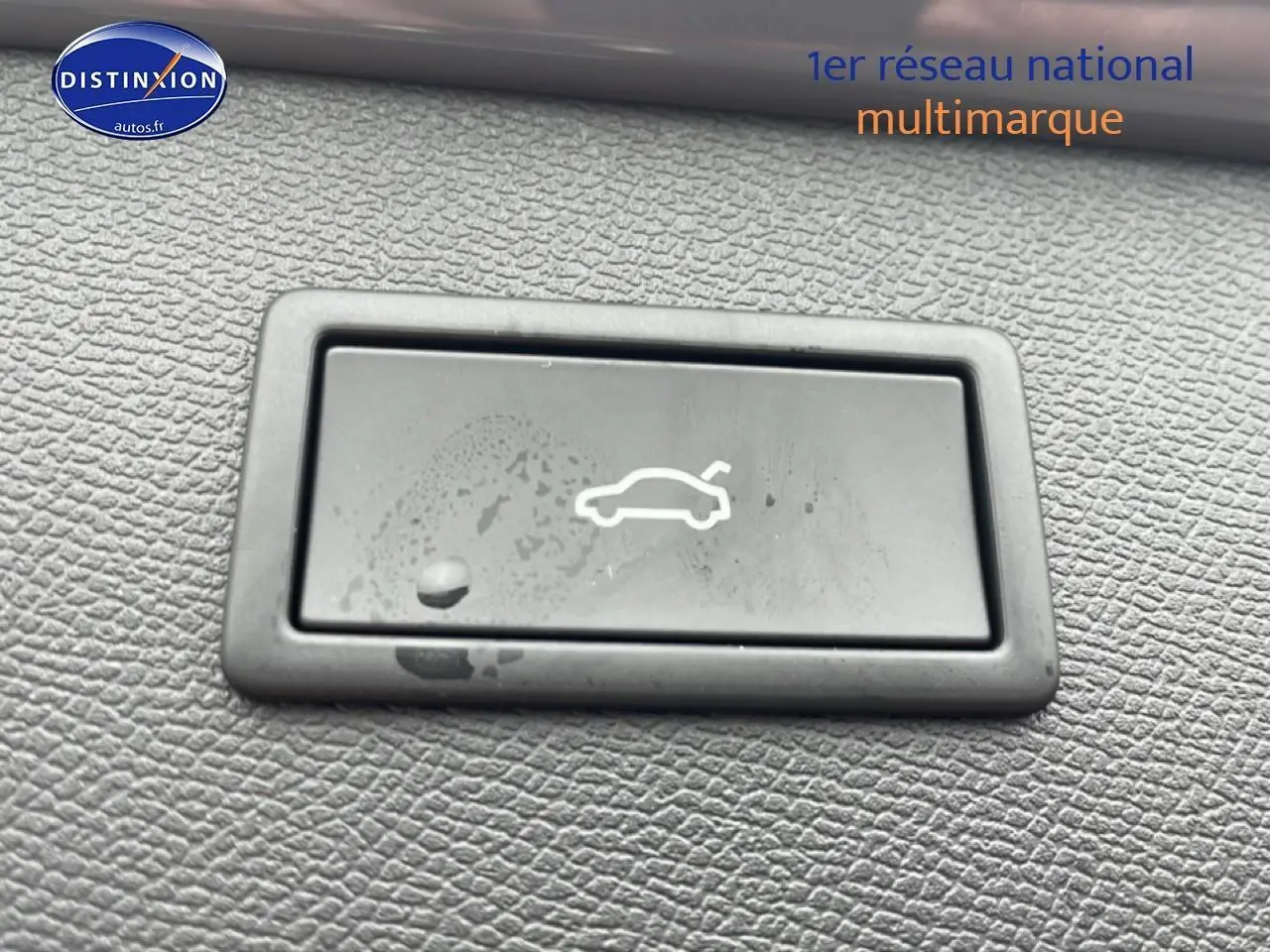 Bouton d'ouverture du coffre sur tableau de bord en plastique noir texturé d'une CUPRA Formentor gris graphene.