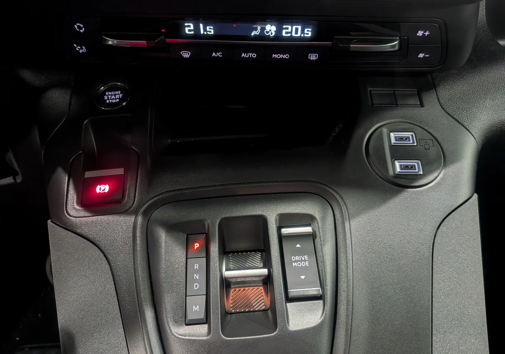 Vue rapprochée de la console centrale du Peugeot Rifter 2025 gris acier, avec commandes de boîte auto et climatisation digitale.