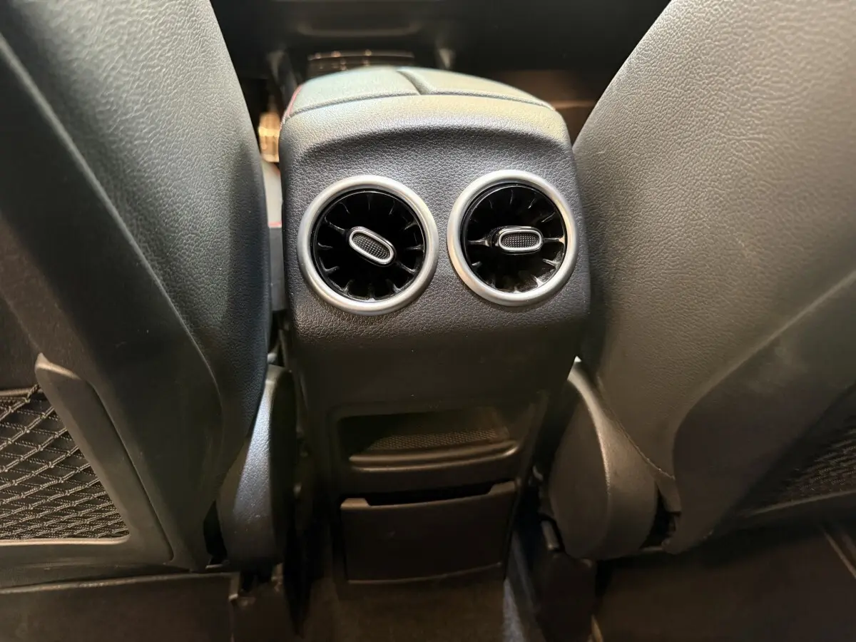Vue rapprochée des aérateurs arrière noirs et chromés entre les sièges avant d’un Mercedes GLA 250 e AMG Line gris clair.