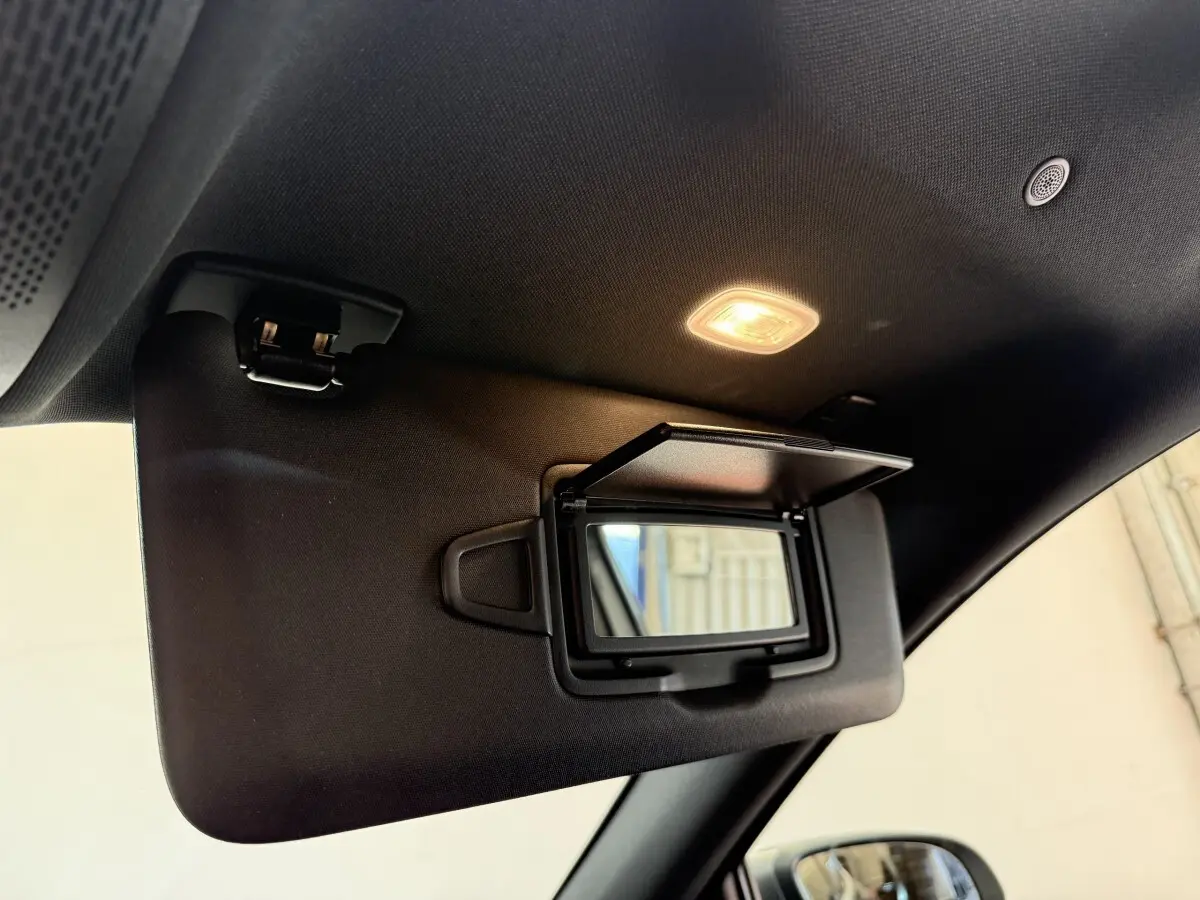 Détail du pare-soleil côté conducteur avec miroir éclairé dans l'habitacle noir du Mercedes GLA 250 e AMG Line 2023.