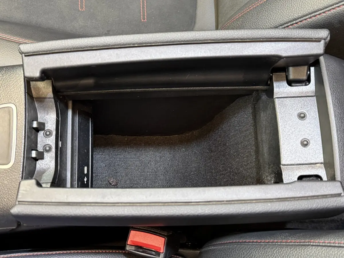 Vue plongeante sur le compartiment de rangement central noir avec surpiqûres rouges dans le Mercedes GLA 250 e AMG Line 2023.