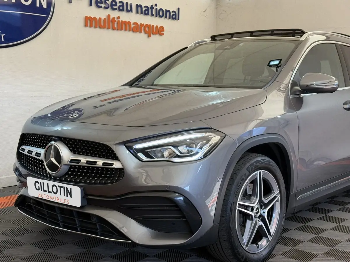 Mercedes GLA 250 e AMG Line gris clair vue 3/4 avant droit, avec calandre étoile et jantes alliage cinq branches.