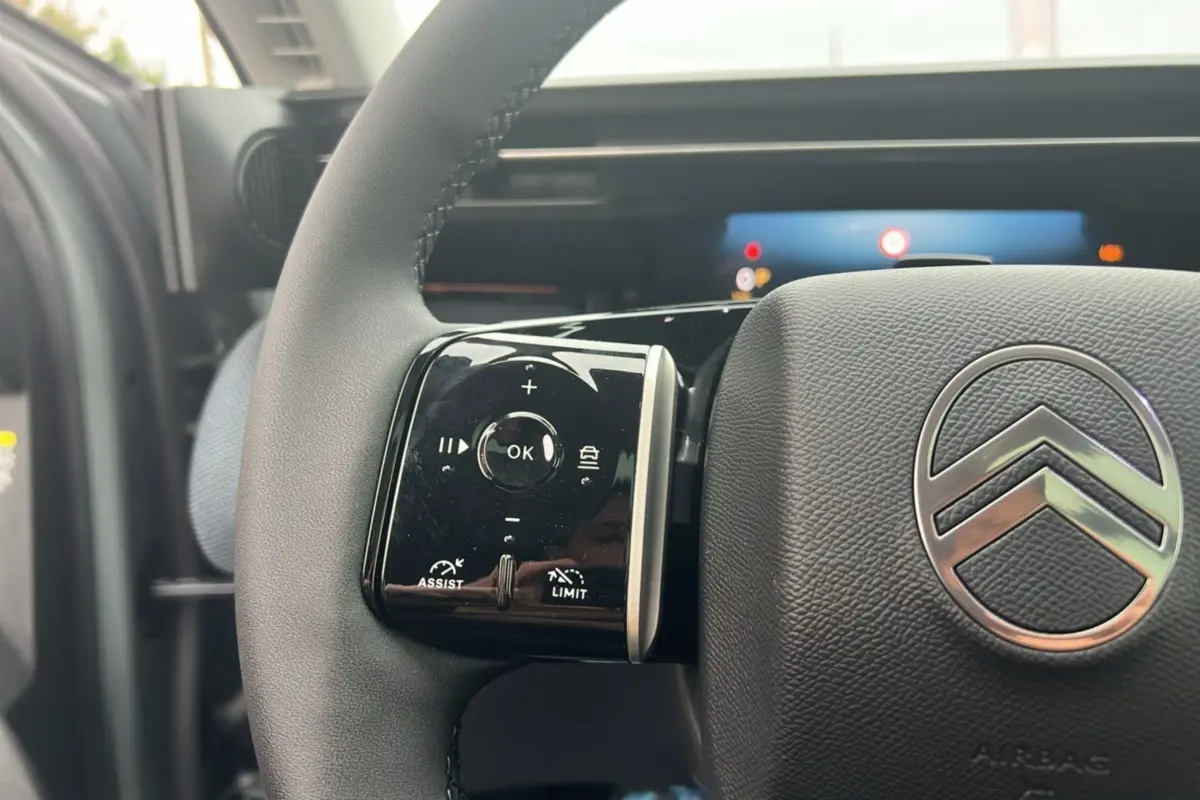 Gros plan sur le volant cuir multifonctions du Citroën C5 Aircross New Hybrid 145 Max T.O avec logo chromé central.