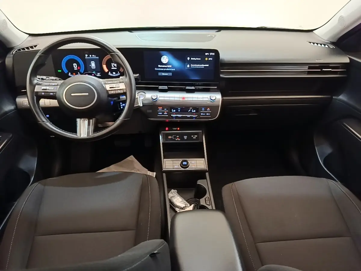 Vue intérieure avant du tableau de bord et volant cuir noir du Hyundai Kona 1.6 Hybrid 2024, avec écran tactile central.