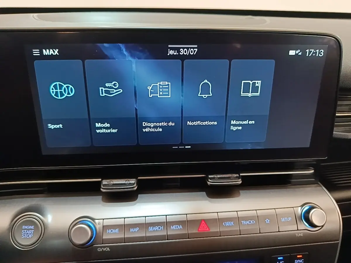 Écran tactile central du tableau de bord du Hyundai Kona 2024 affichant les modes Sport, Mode voiturier et notifications.