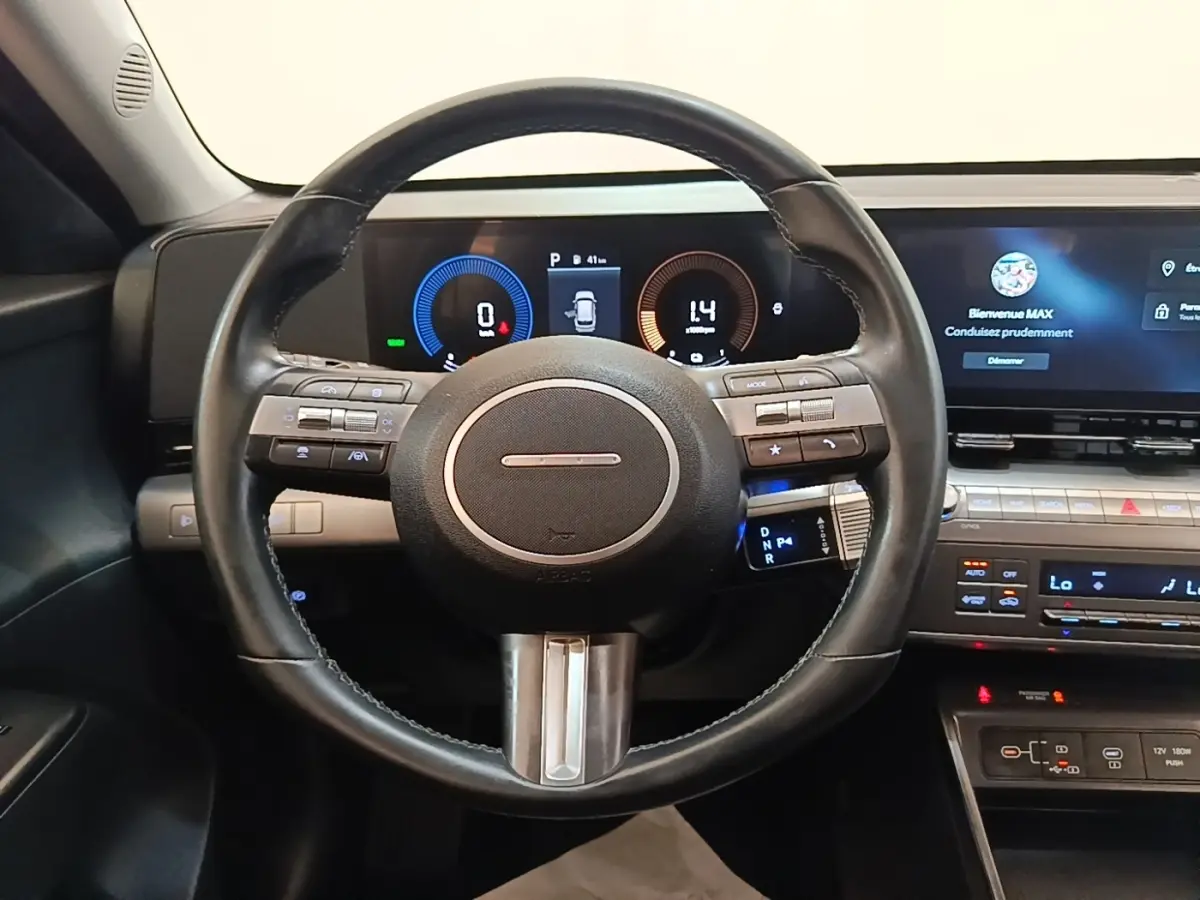 Vue intérieure centrée sur le volant cuir et le tableau de bord numérique du Hyundai Kona 1.6 Hybrid 2024.