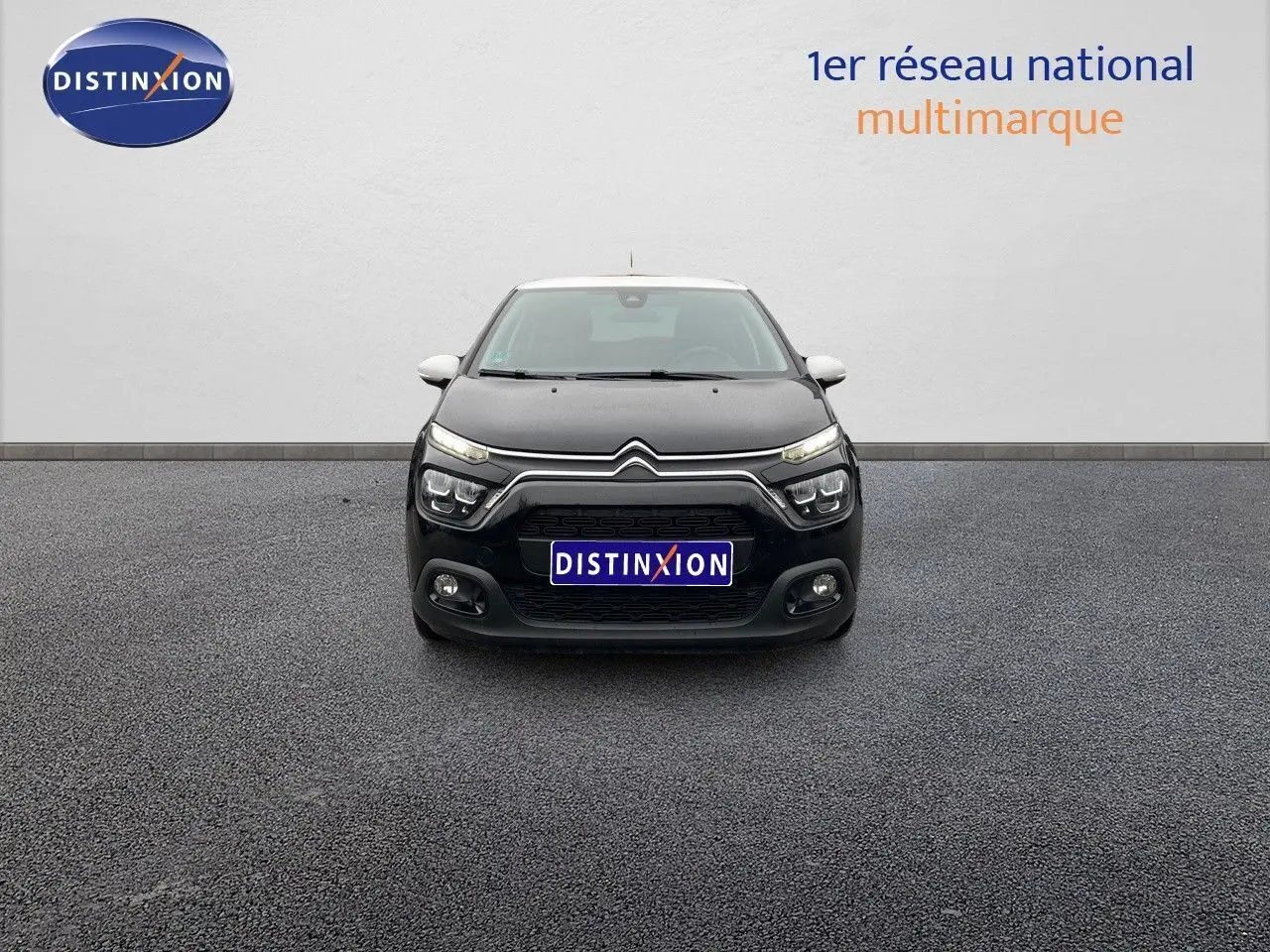 Citroën C3 noire métal vue de face avec ses phares LED distinctifs allumés sur fond neutre.