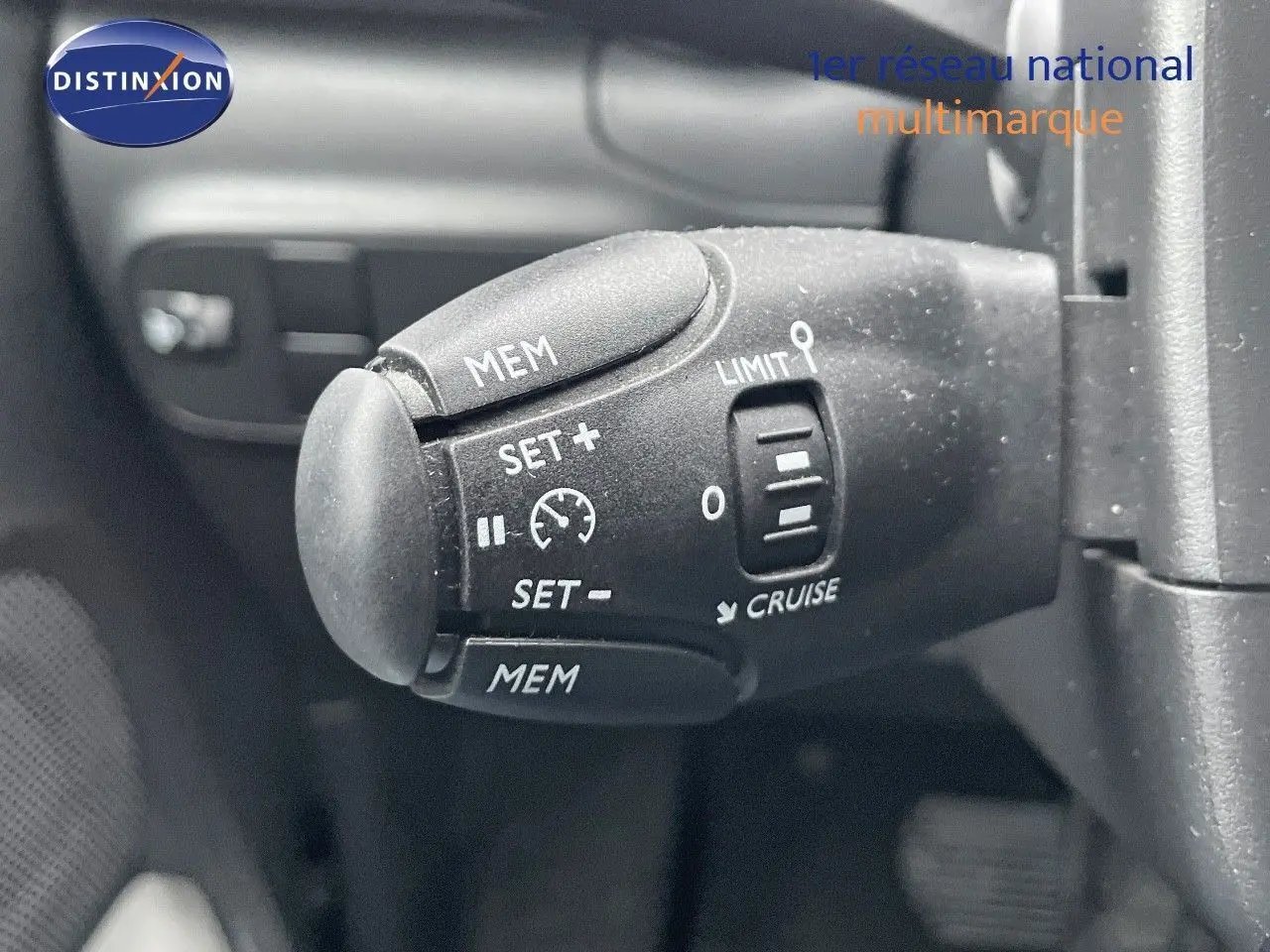 Gros plan sur la commande de régulateur de vitesse du Citroën C3 noir métal 2023, côté volant à gauche.