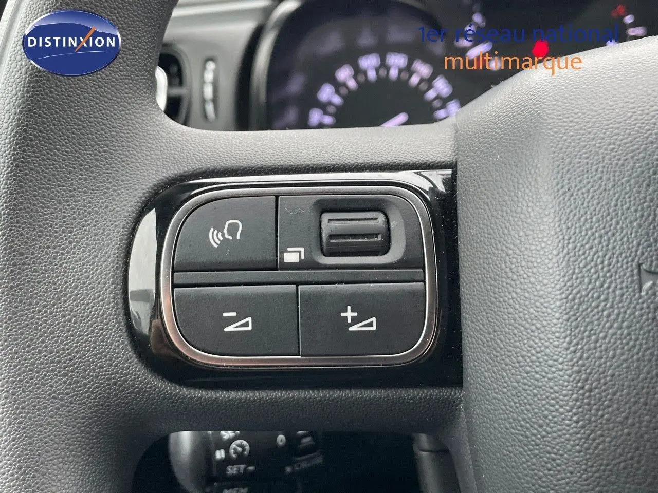 Gros plan sur les commandes de volume et de téléphone au volant d'une Citroën C3 noire métal 2023.