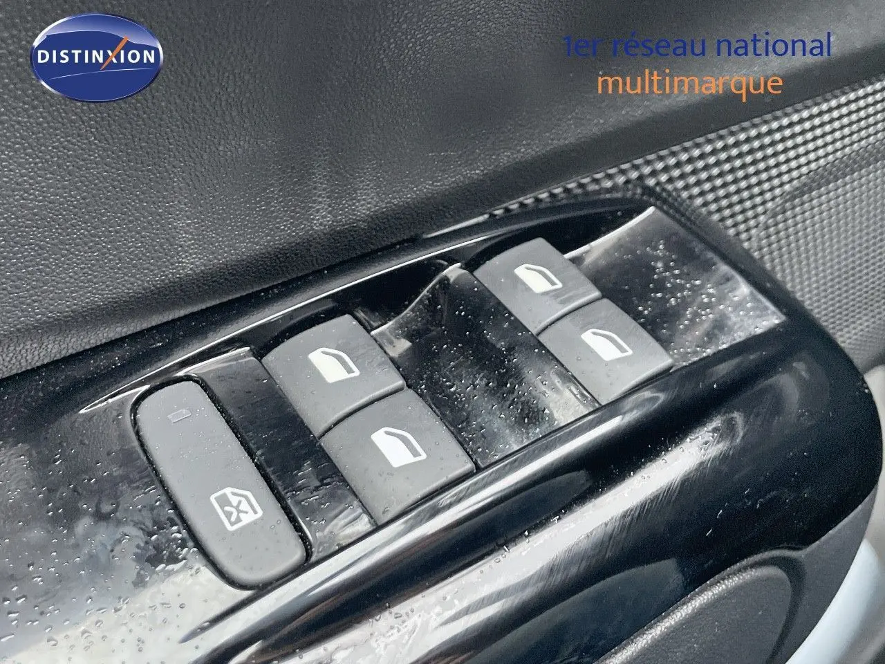 Gros plan sur les commandes de lève-vitres côté conducteur d'une Citroën C3 noire métal 2023.