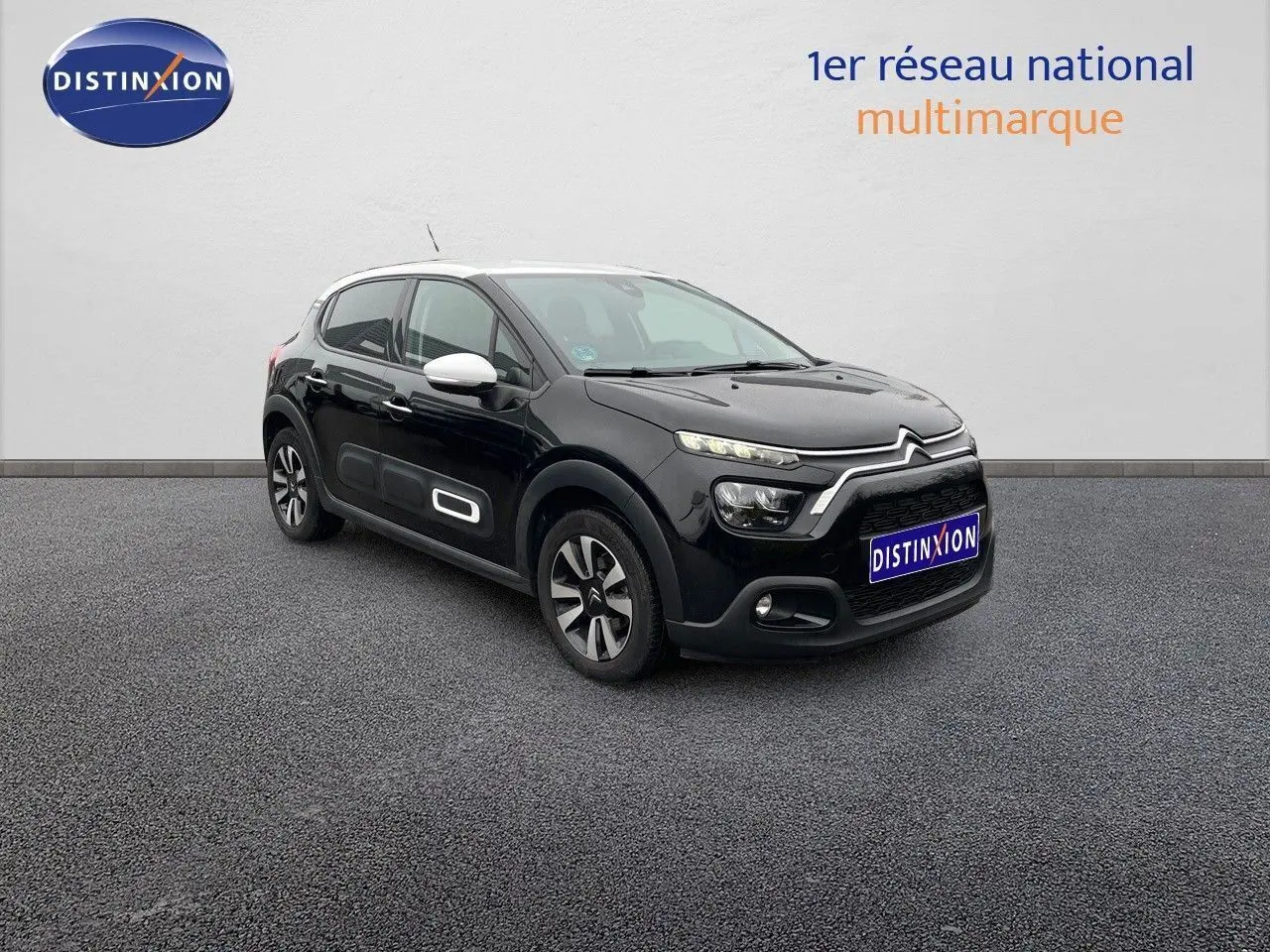 Citroën C3 noire métal vue 3/4 avant droit avec coques de rétroviseurs blanches et jantes bi-ton.