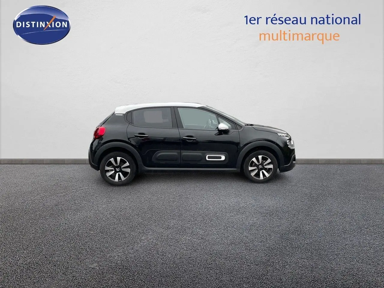 Profil côté droit d'une Citroën C3 noire métal 2023 avec toit blanc et protections latérales distinctives.