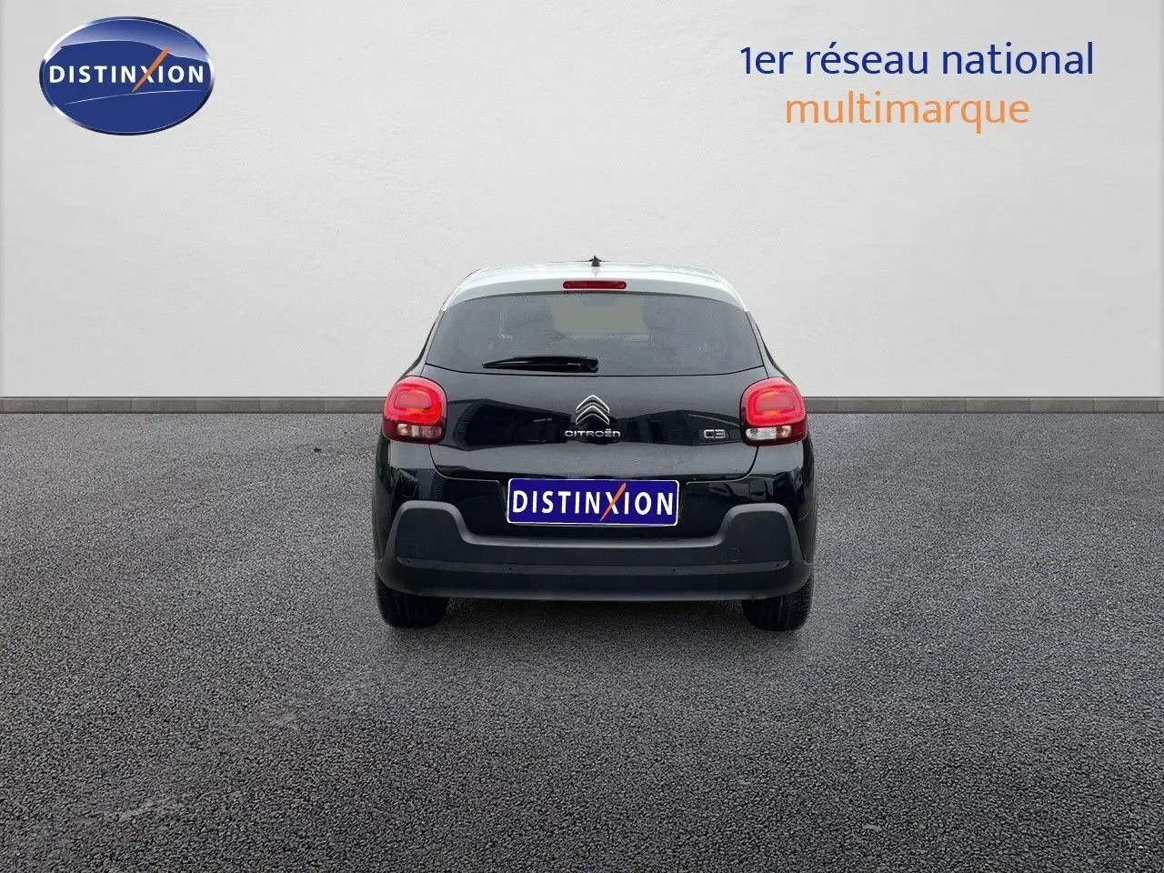 Vue arrière d'une Citroën C3 noire métal 2023 avec toit blanc, feux rouges et logo Citroën visible.