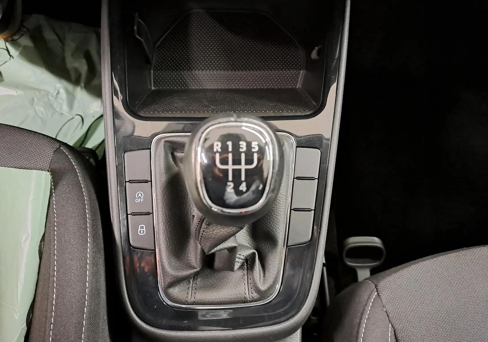 Vue rapprochée du levier de vitesses manuel de la Skoda Fabia 2023 avec console noire et sièges gris.