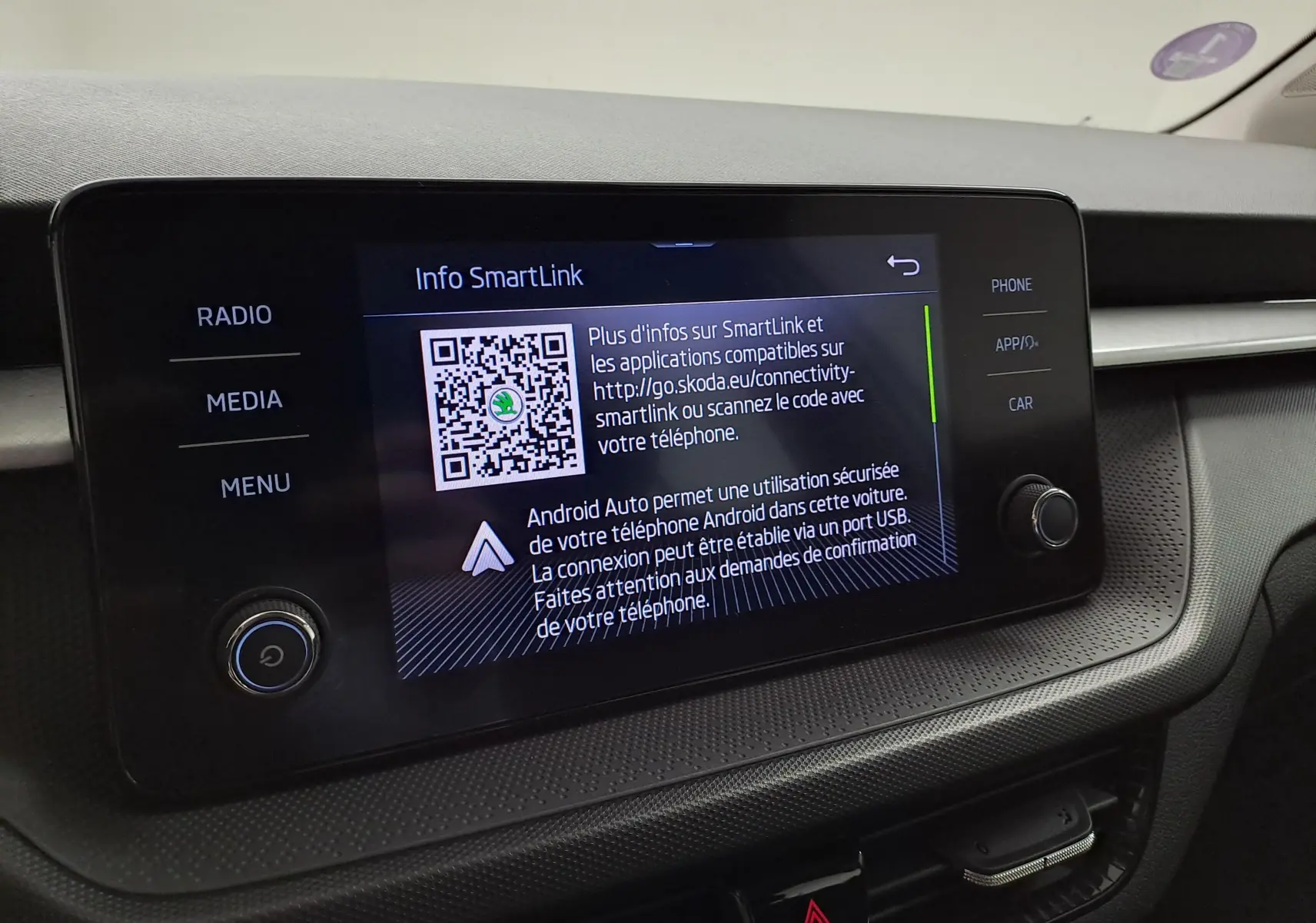 Écran tactile central affichant l'interface SmartLink dans l'habitacle d'une Skoda Fabia blanche 2023.