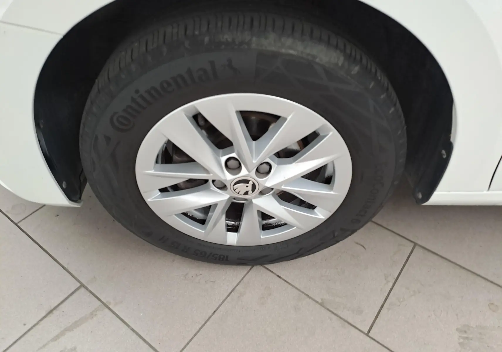 Gros plan sur la roue avant gauche d'une Skoda Fabia 2023 blanc candy avec jante alliage et pneu Continental.