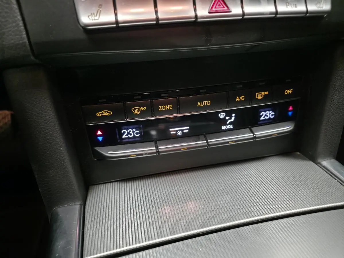 Détail de la console centrale avec commandes de climatisation affichant 23°C sur Mercedes Classe E noire 2015.