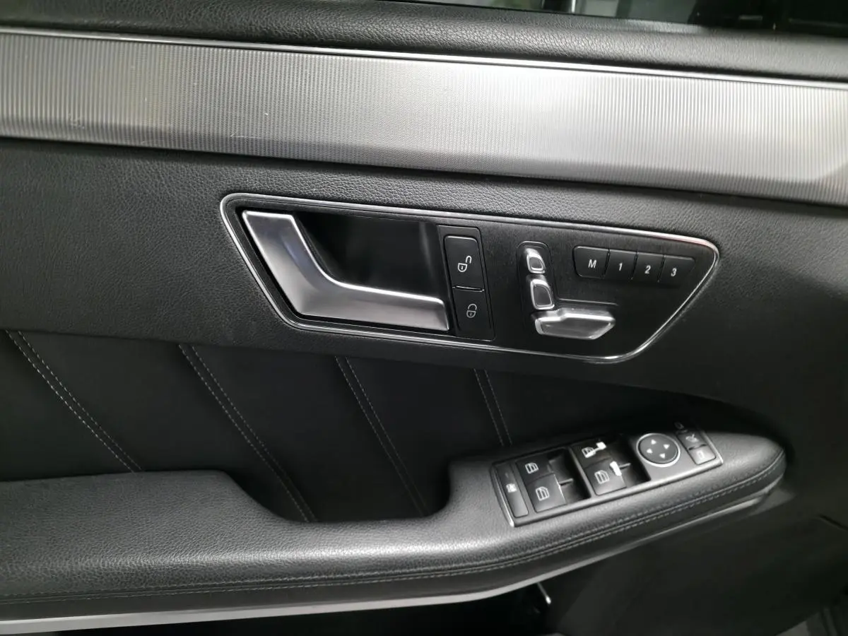 Gros plan sur la garniture intérieure noire côté gauche de la porte avant d'une Mercedes Classe E E 300 BlueTEC Hybrid 2015.