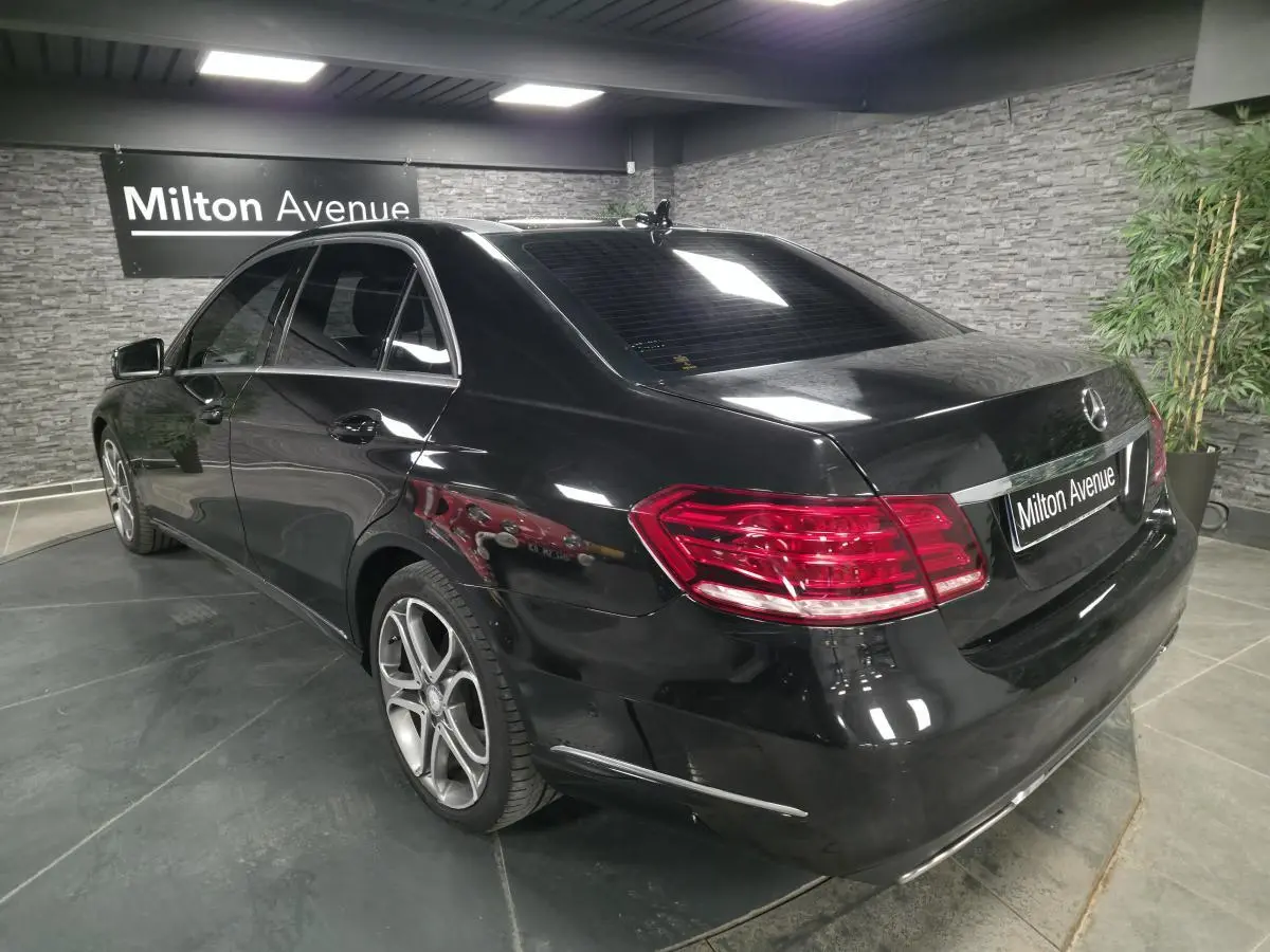 Vue 3/4 arrière droite d'une Mercedes Classe E noire avec jantes alliage 5 branches doubles et feux arrière LED.