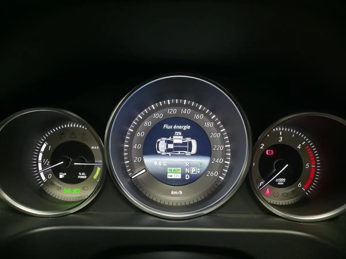Tableau de bord de Mercedes Classe E 300 BlueTEC Hybrid 2015 avec affichage numérique du flux d'énergie et compte-tours.
