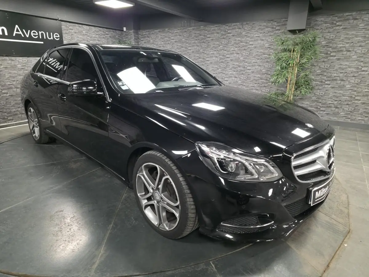 Mercedes Classe E 300 BlueTEC Hybrid noire vue en 3/4 avant avec jantes alliage 18 pouces et calandre à deux lamelles.